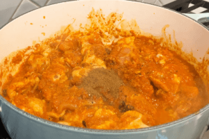 Add garam masala and group coriander for spicy Indian red chicken curry