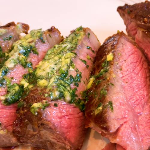 Serve the steak for Reverse-Seared New York Strip Steak with Garlic-Basil Butter