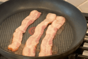 Cook the bacon for Steak and Eggs Breakfast