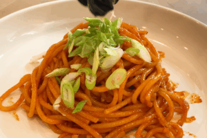 Garnish with green onions for Spicy Gochujang Buttered Noodles