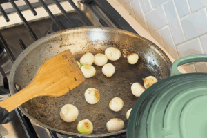 Cook pearl onions for Authentic Beef Bourguignon