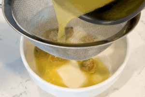 Strain the cooking liquid (clam broth) for Garlic Clam and Shrimp Pasta