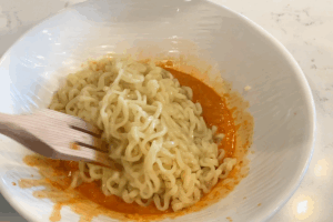 Combine the sauce and noodles for Creamy Instant Noodle Carbonara Hack