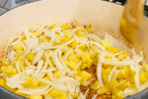Add the onions for One-Pan Sausage and Sauerkraut