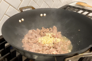 Season and add garlic for Mapo tofu